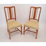 A pair of Edwardian satinwood slat back chairs on square tapered supports with spade feet