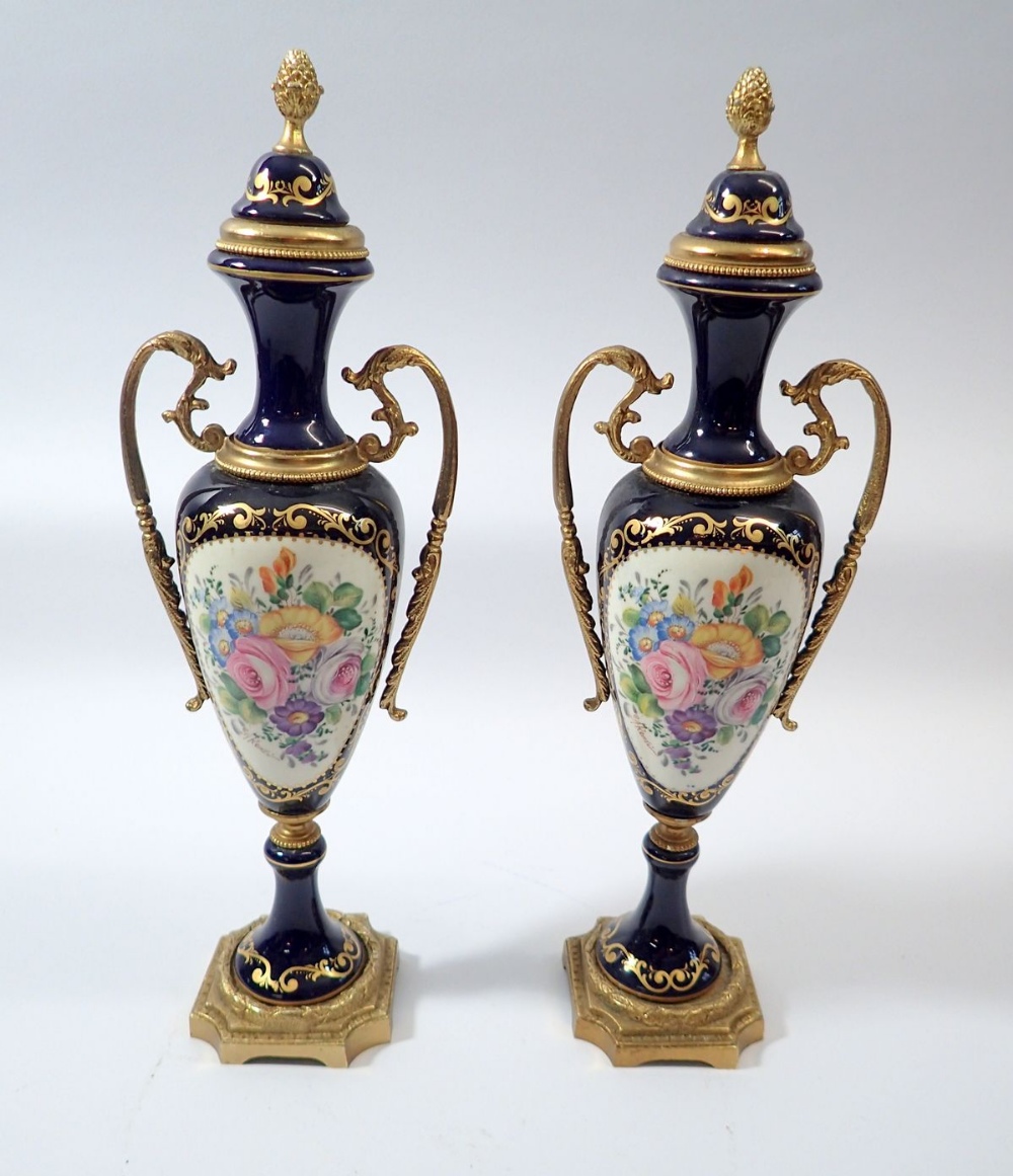 A pair of ACF serves style vases painted reserves of flowers signed Kenzi with gilt metal mounts,