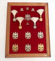 A framed display of seven Royal Artillery helmet plates, four hackles and four cap badges