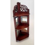 An Edwardian mahogany set of mirrored corner shelves with decorated pierced surmount, 80cm tall