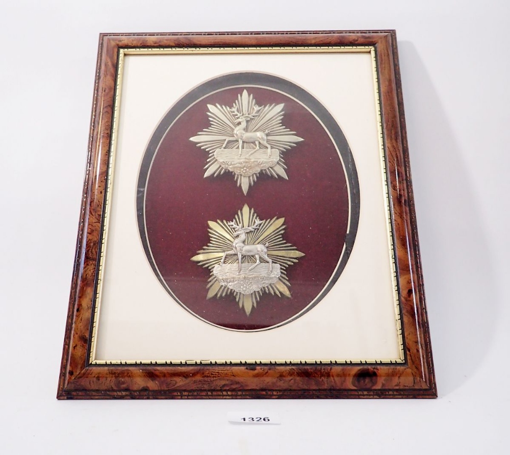 A framed display of two Hertfordshire Rifle Volunteer helmet plates