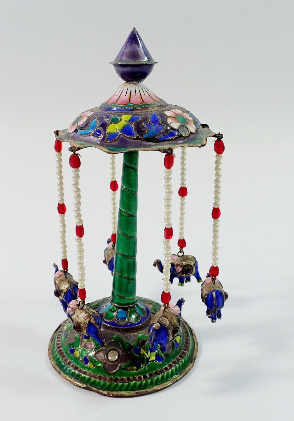 An Indian silver and enamel miniature merry go round with six elephants suspended on beaded poles,