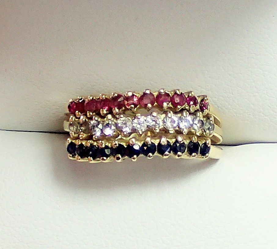 A 14 carat gold triple band ring set red, white and blue stones, size O to P, 4g