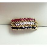 A 14 carat gold triple band ring set red, white and blue stones, size O to P, 4g