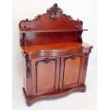 A Victorian mahogany chiffonier with shelf back over serpentine front, the two panelled cupboards