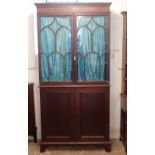 A Regency mahogany bookcase with two Gothic arch glazed doors over panelled cupboard, all on bracket