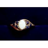A 9 carat gold ring set opal flanked by six sapphires, size M, 1.1g