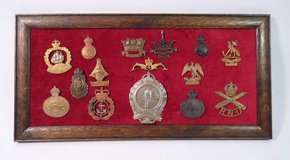 A framed display of fifteen Royal Navy cap badges including 'Strike Hawke', 'Steady Hood', 'Mine