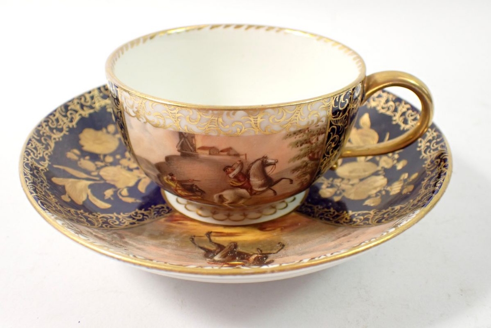 A Meissen cabinet cup painted scenes of men fighting on horseback alternating with blue and gilt