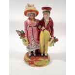 An early Staffordshire group of a man and woman standing with baskets of flowers, 16cm tall