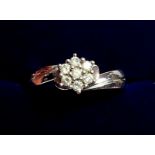 A white metal ring crossover set cluster of diamonds, size M to N, 5.2g
