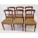 A set of six early 19th century rosewood dining chairs with scrollwork carved bar backs and turned