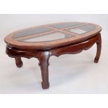 A Waring & Gillows oriental style oval coffee table with inset glass panels to top, 122 x 74 x 44cm