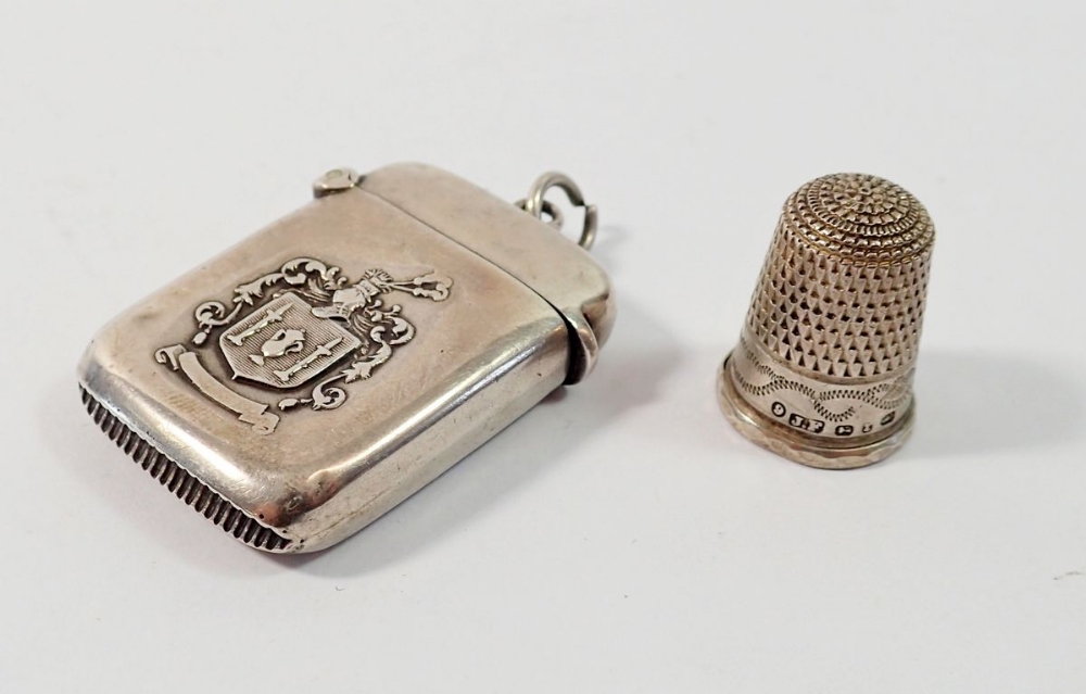 A silver vesta case with armorial and presentation inscription, Birmingham 909 and a silver thimble,