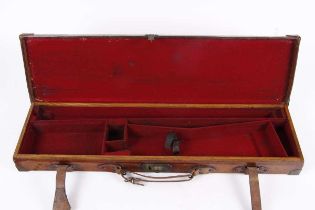 An oak and leather gun case, red baize lined interior fitted for 30 ins barrels, brass corners