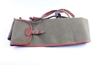 A Kennedy canvas and leather gun slip, and a green canvas rifle slip (2)