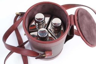 A cased flask set; three flush-fitted flasks within leather holder, the rim embossed Purdey, with