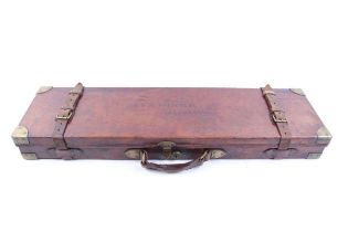 A good oak and leather gun case with brass corners, embossed E.E.M. Bottomley, Bradford, red baize