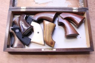 Wooden case containing various pistol and revolver grips