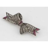 A continental white metal and paste set bow brooch,