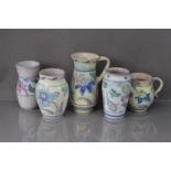 Five vintage Honiton and other terracotta and floral decorated jugs and vases,