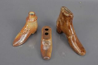 A group of three 19th Century salt glazed treacleware shoe shape items,