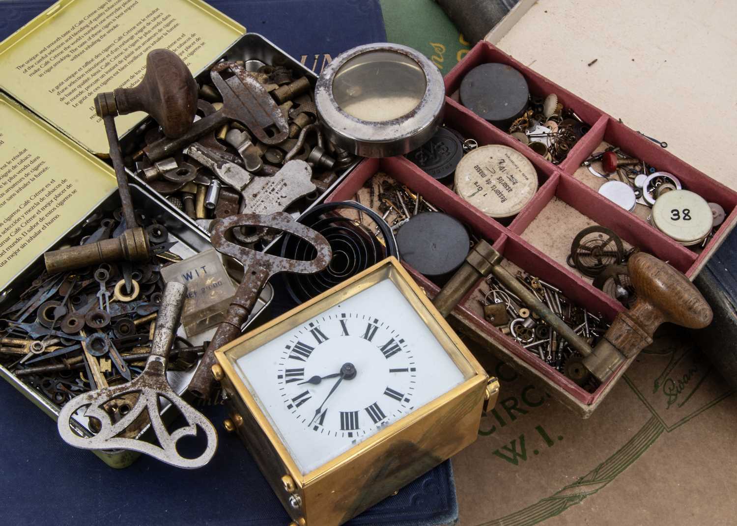 A collection of clock and watch spare parts and related items,