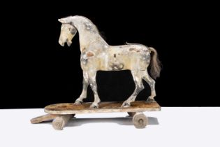 A late 19th century English carved and painted wooden horse on wheels,