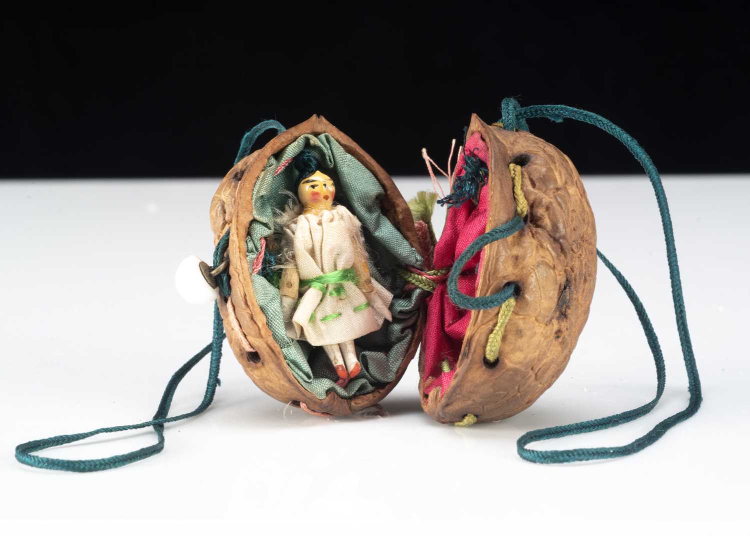 An 19th century miniature Grodnerthal doll in a walnut shell purse,