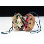 An 19th century miniature Grodnerthal doll in a walnut shell purse,