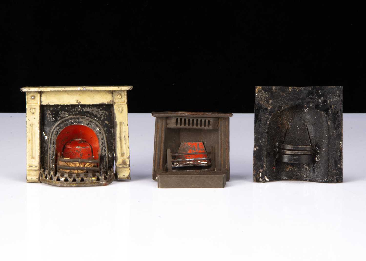 Three 19th century painted tinplate dolls’ house fireplaces,