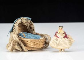 A miniature Grodnerthal dolls’ house doll in cradle,