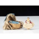 A miniature Grodnerthal dolls’ house doll in cradle,