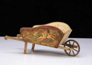 A French lithographed tinplate and wooden dolls’ wheelbarrow,