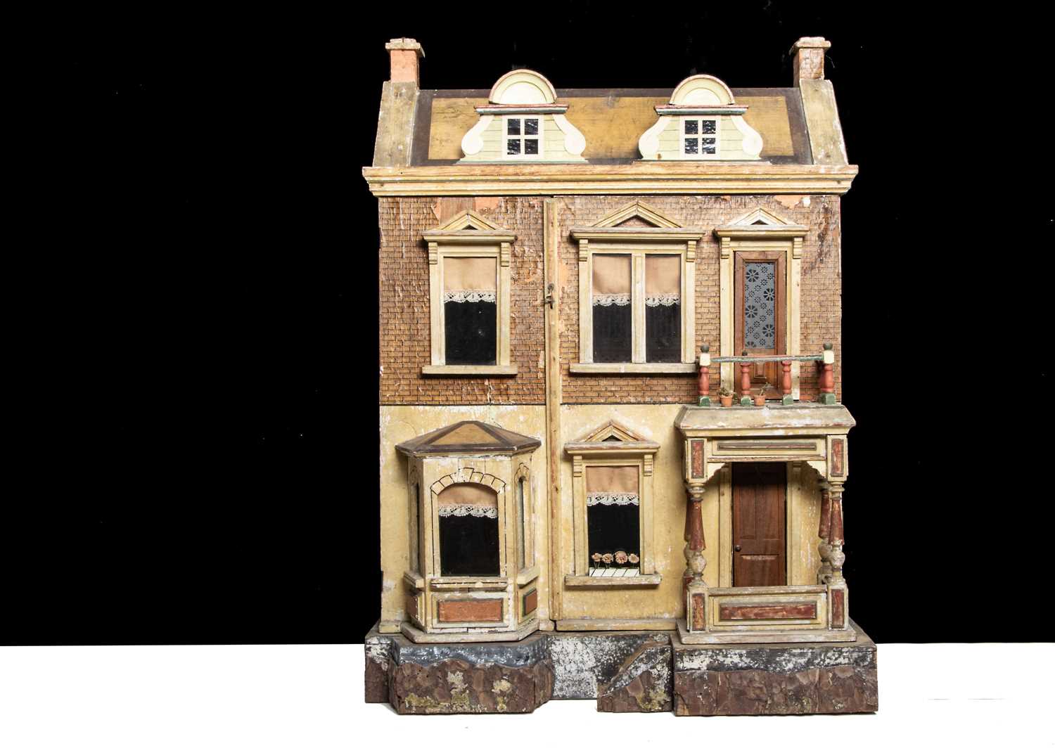 A Gottschalk wooden dolls’ house raised on a bark base,