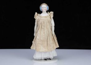 A late 19th century German bisque shoulder head doll with net snood and ribbons in hair,