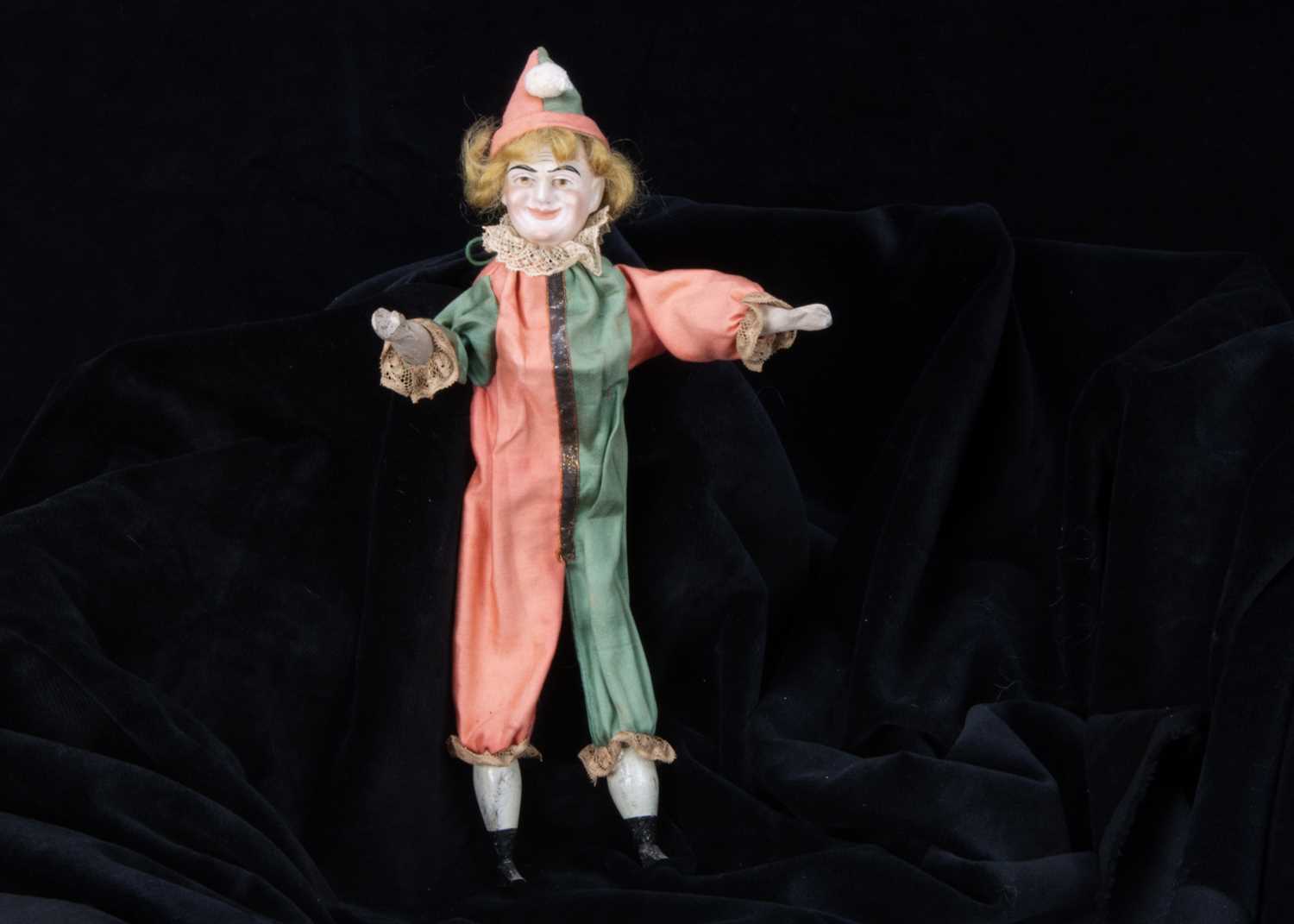 An unusual bisque headed squeak toy clown,