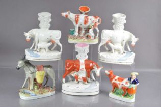 Five Staffordshire flat back cow form spill vases and a donkey,