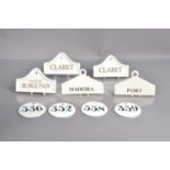 A group of nine porcelain and pottery wine bin labels,