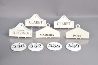 A group of nine porcelain and pottery wine bin labels,