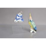 A vintage Karl Ens model of a parrot and a Bing & Grondahl figure of a girl with a doll,