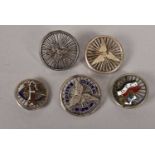 A group of five white metal cycling badges,