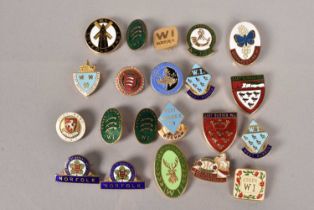 An assortment of Women's Institute enamel pin badges,