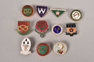 An assortment of Women's Institute enamel pin badges,