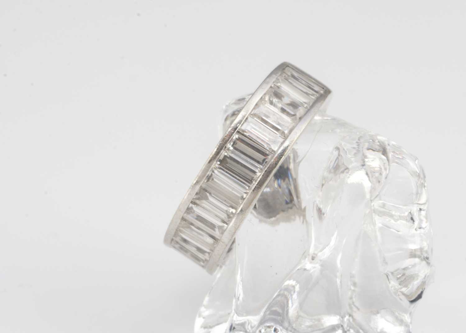 A continental white gold diamond baguette channel set three-quarter eternity ring,