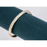 A yellow metal bangle set with CZ's,