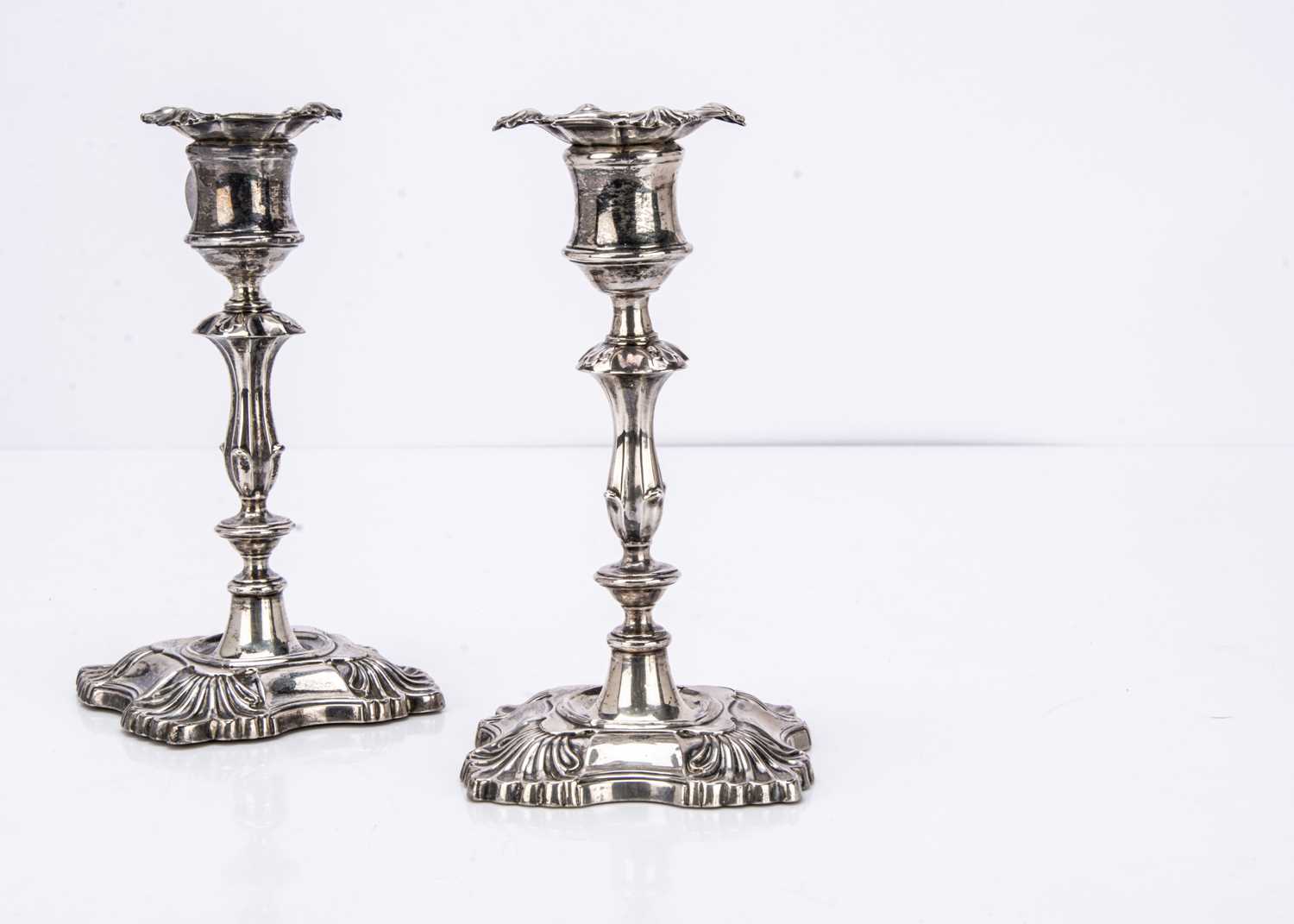 A pair of Edwardian silver filled short candlesticks,