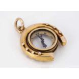 An Edwardian horseshoe high carat gold compass charm,