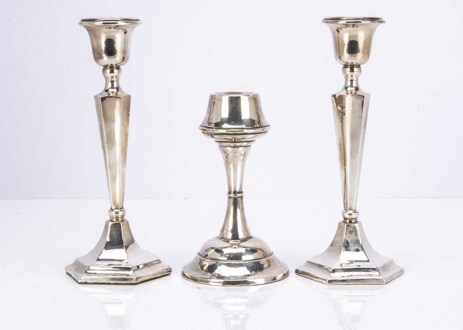 A pair of Art Deco period silver filled candlesticks and another