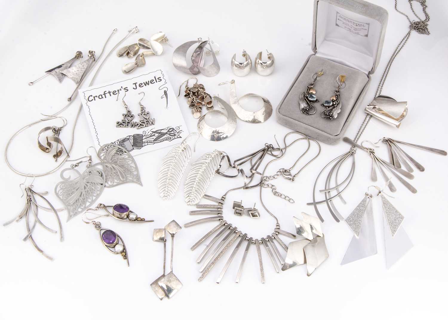 A collection of silver, white metal and plated earrings and jewels,